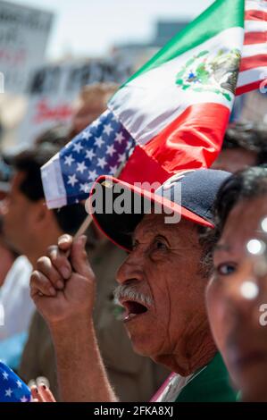 2009 winkt ein Mann bei einer Mayday-Kundgebung in Downtown Los Angeles zusammen mit einer amerikanischen und einer mexikanischen Flagge. Stockfoto