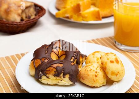 Nahaufnahme des Tellers mit Faden mit Schokoladenvereisung und Käsebrot. Orangensaft. Stockfoto