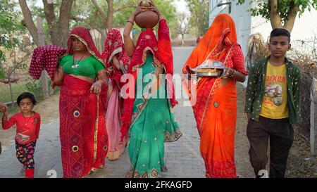 08. April 2021- Reengus, Sikar, Indien.Religiöse Hindu-Frauen halten heiligen Wasserkrug auf dem Kopf. Religiöse indische Frauen in ihrer traditionellen Kleidung. Stockfoto