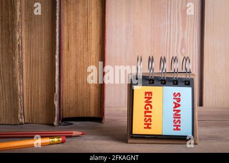 Englisch und Spanisch lernen. Bücher auf einem hölzernen Bücherregal. Stockfoto