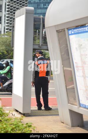Senayan, Jakarta, Indonesien - 23. April 2021: Ein Offizier mit orangefarbener Weste der Transportbehörde kontrolliert den Verkehr. Stockfoto