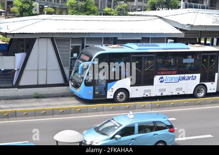 Senayan, Jakarta Indonesien, 23. April 2021: Ein weiß-blauer Transjakarta-Bus hält an der Bushaltestelle. Stockfoto