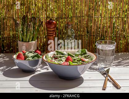 Frische Erdbeeren, grüner Spargel, Feta-Käse, Babyspinat und Rucola-Salat in einer Schüssel serviert Stockfoto