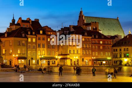 Warschau, Polen - 28. April 2021: Abendliches Panorama auf den Schlossplatz mit bunten Mietshäusern und Silhouette der St. Jogn Kathedrale in der Altstadt Stockfoto