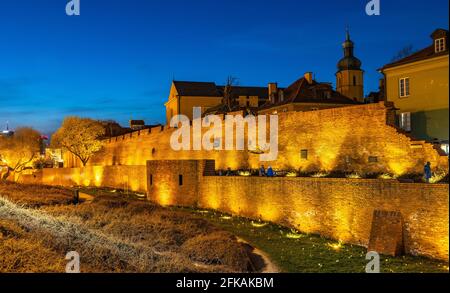 Warschau, Polen - 28. April 2021: Abendliches Panorama der Stadtmauern, des Grabens und der Mietshäuser in der Altstadt von Starowka Stockfoto