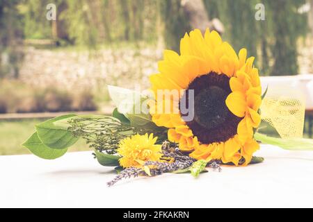 Blumenstrauß für Hochzeit mit großer Sonnenblume und naturalistischem Land Hintergrund - Hochzeitsreportage Stockfoto