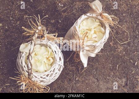 Holzkorb mit weißen Rosenblättern, Dekoration für Hochzeitszeremonie Stockfoto