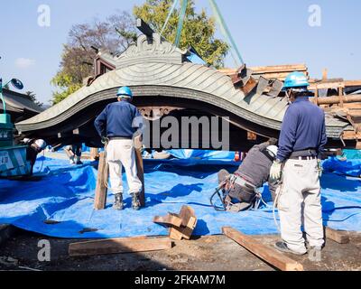 Aso, Japan - 5. November 2016: Das Dach der eingestürzten Halle wurde nach den Erdbeben in Kumamoto 2016 von den Arbeitern im schwer beschädigten Aso-Schrein vorsichtig angehoben Stockfoto