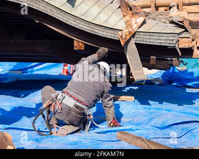 Aso, Japan - 5. November 2016: Das Dach der eingestürzten Halle wurde nach den Erdbeben in Kumamoto 2016 von den Arbeitern im schwer beschädigten Aso-Schrein vorsichtig angehoben Stockfoto