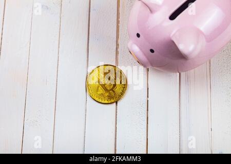 Schweinebank und Bitcoin auf weißem Holzhintergrund, Draufsicht. Stockfoto