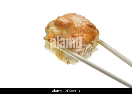 Essstäbchen halten gebackene Sushi-Rolle mit Sauce Stockfoto