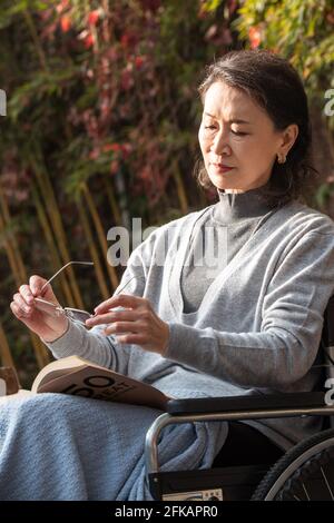 Eine einsame alte Frau im Hof in der Sonne Stockfoto