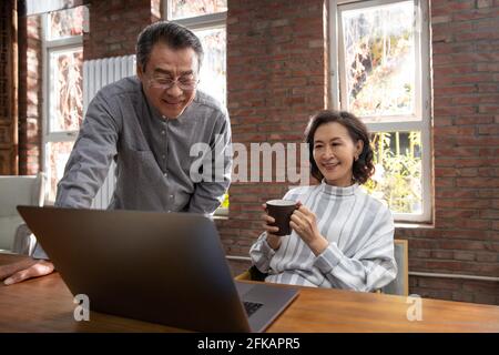 Glückliches, älteres Paar, das Laptops verwendet Stockfoto