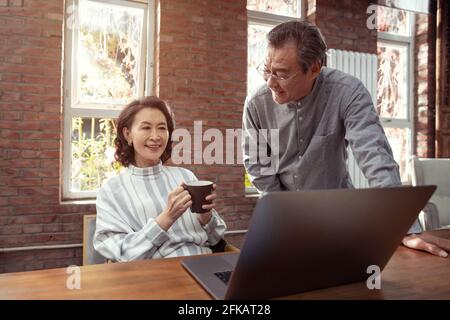 Glückliches, älteres Paar, das Laptops verwendet Stockfoto