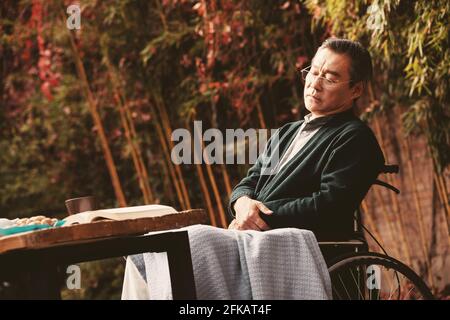 Ein einsamer alter Mann im Hof in der Sonne Stockfoto