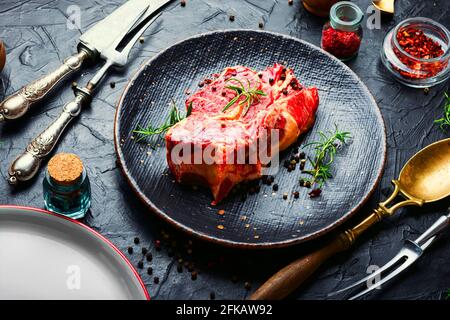 Rohes Rinderfleisch mit Rosmarin und Gewürzen.Rohes Rindersteak Stockfoto