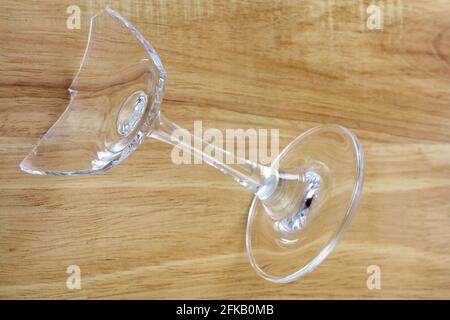 Nahaufnahme von zerbrochenem Cocktailglas auf Holzhintergrund Stockfoto