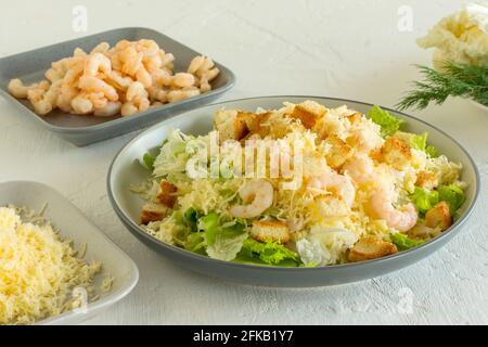 Hausgemachter Shrimp Caesar Salat mit Parmesa, Sauce und Croutons auf weißem Hintergrund. Stockfoto