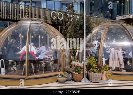Da die Sperrbeschränkungen von Covid weiterhin lockern und unwesentliche Geschäfte wieder eröffnet werden, genießen die Gäste am 26. April 2021 in London, England, das Restaurant „Coppa Club“, das sich unterhalb von Luxusapartments in der Nähe des Tower of London befindet, im Freien. „Coppa Club“ gehört zur Restaurantkette der Strada, die sich auf italienische Küche spezialisiert hat. Stockfoto
