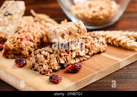 Bund gemischter glutenfreier Müsliriegel mit getrockneten Früchten & verschiedenen Nüssen, Holzhintergrund. Gesundes veganes Superfood, verschiedene Fitnessdiät sn Stockfoto