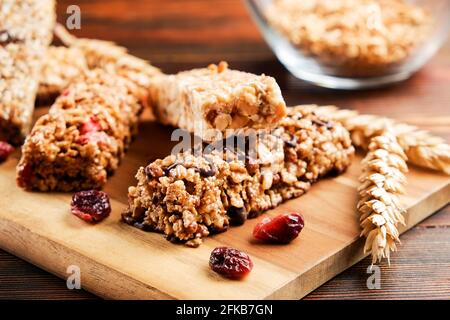 Bund gemischter glutenfreier Müsliriegel mit getrockneten Früchten & verschiedenen Nüssen, Holzhintergrund. Gesundes veganes Superfood, verschiedene Fitnessdiät sn Stockfoto