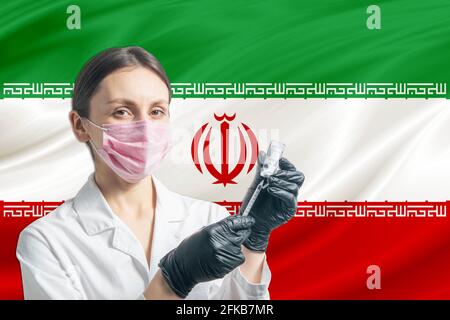 Ärztin bereitet die Impfung vor dem Hintergrund der Iran-Flagge vor. Impfkonzept Iran. Stockfoto