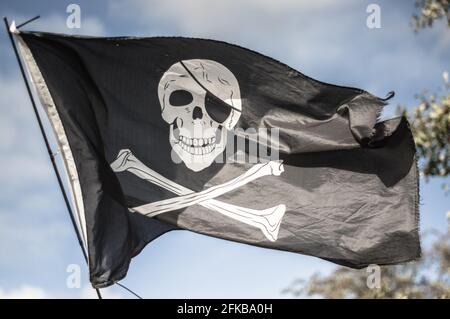 Eine Flagge von Jolly Roger, die über einem Schmalboot in London, Großbritannien, fliegt. Stockfoto