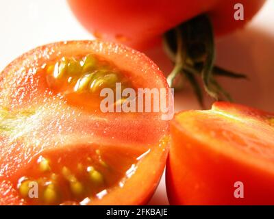 Gartentomate (Solanum lycopersicum, Lycopersicon esculentum), halbierte Tomate auf einem Teller Stockfoto