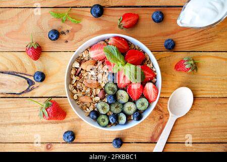 Servieroption einer Müslischale mit einer Mischung aus Nüssen, Müsli, Obst und Beeren sowie griechischem Joghurt. Gesundes vegetarisches Frühstück, Bio-Erdbeere, Blauberr Stockfoto