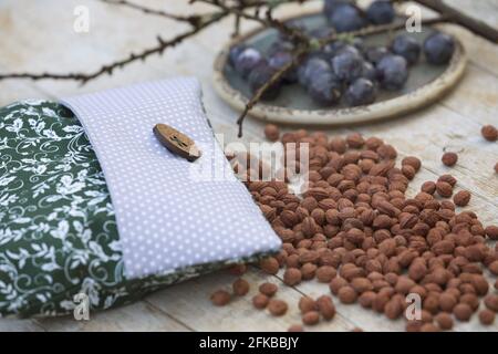 Schlehdorn, Schlehe (Prunus spinosa), Schlehenkernkissen, Schlehenkerne werden in einen Kissenbezug gegeben und bei Bedarf im Ofen erhitzt Stockfoto