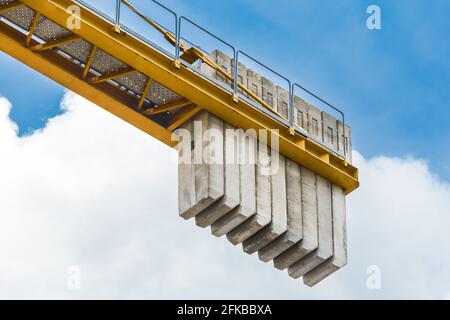 Weißrussland, Minsk - 28. Mai 2020: Ein Gegengewicht von Betonblöcken auf dem Heck eines Industriekrans für den Turmbau gegen den blauen Himmel. Nahaufnahme. Stockfoto