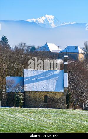 Vorderansicht eines kleinen Häuschens und des im Hintergrund aufsteigenden Alpenbergs. Stockfoto