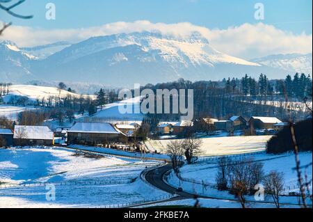 Atemberaubende Aussicht auf die Alpen Bergkette hinter einer kleinen Stadt am Fuße des Berges. Stockfoto