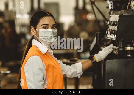 Frauen Arbeiter tragen Einweg-Gesichtsmaske zum Schutz Corona Virus Verteilung und Rauch staubigen Luftverschmutzungsfilter in der Fabrik für eine gesunde Arbeitspflege. Stockfoto