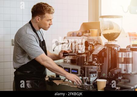 Barista, der italienischen Espresso mit der Espressomaschine zubereitet Das Café Stockfoto