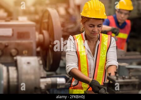 Amerikanische schwarze Frauen Teen-Arbeiter arbeiten Teilzeitjob als Arbeit in der Industrie Fabrik mit schweren Stahlmaschine. Stockfoto