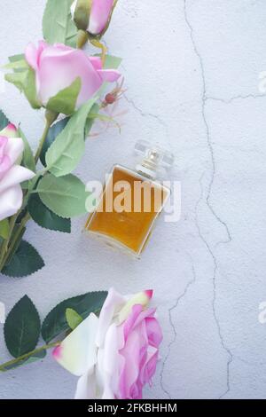 Flache Komposition aus Parfüm und rosa Rosenblüte auf Weiß Hintergrund Stockfoto