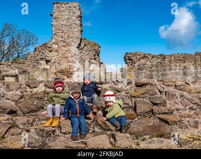 East Lothian, Schottland, Großbritannien, 30. April 2021. Historisches Umfeld Schottland mittelalterliche Burgen wieder geöffnet: Die ersten Besucher kommen an einem kühlen, sonnigen Morgen an buchbaren Stundenabenden für einen Besuch der Ruinen von Dirleton Castle, während HES im letzten Jahr zum zweiten Mal im ganzen Land Sehenswürdigkeiten wiedereröffnet. Im Bild: Diese Jungen im Alter zwischen 1-3 Jahren genossen es, auf einer zerstörten Wand zu klettern Stockfoto