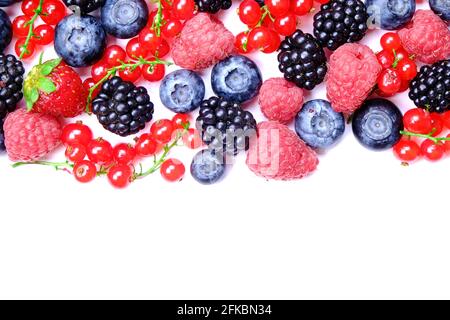 Ein Haufen gemischter Beeren im Erntestapel auf weißem Hintergrund. Farbenfrohe Komposition mit frischen Bio-Erdbeeren, Heidelbeeren, Brombeeren und roten Johannisbeeren. Cl Stockfoto