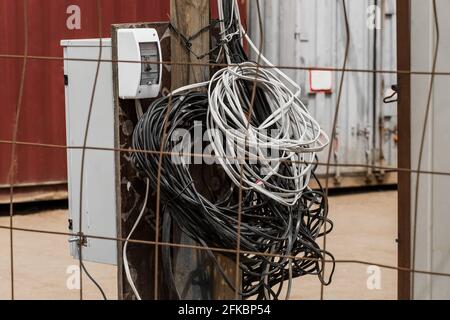 Ein Haufen Drähte, ein elektrisches Beleuchtungssystem im Hintergrund einer Baustelle, Nahaufnahme. Stockfoto