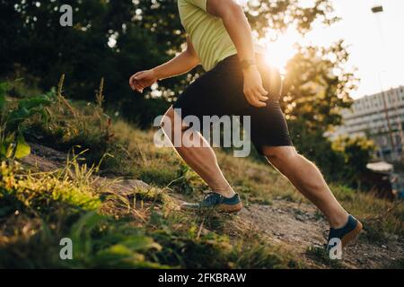 Niedriger Abschnitt des männlichen Athleten, der an Land läuft Stockfoto