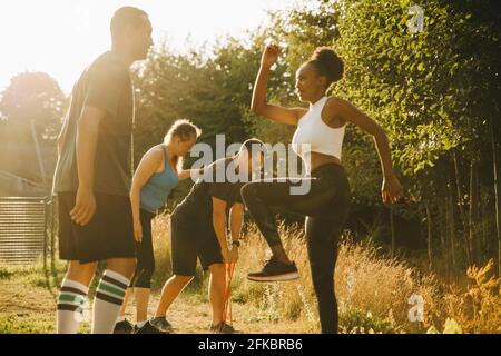 Männliche und weibliche Athleten üben im Park Sporttraining Stockfoto