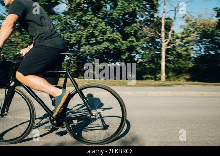 Niedriger Abschnitt des Sportlers Radfahren auf der Straße während des sonnigen Tages Stockfoto