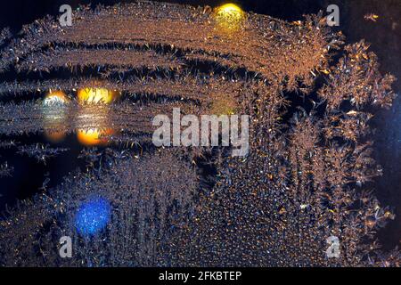 In der Nacht gefrorenes Fensterglas. Nacht im Winter . Eismuster auf dem Glas Stockfoto