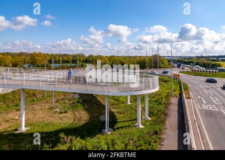 Hängebrücke über die A45 bei den Geschäften von Rushden Lakes, Northampton, England, Großbritannien. Stockfoto