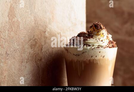 Milchkaffeecocktail mit Schlagsahne, bestreut mit Schokoladenbröseln. Speicherplatz kopieren. Stockfoto