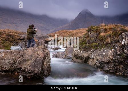 Männlicher Fotograf bei den Fairy Pools auf der Isle of Skye, Inner Hebrides, Schottland, Großbritannien, Europa Stockfoto