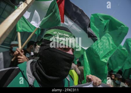 Jabalia, Palästinensische Gebiete. April 2021. Anhänger der islamistischen Bewegung der palästinensischen Hamas schwenken während einer Demonstration gegen die Verschiebung der palästinensischen Wahlen, die am 22. Mai stattfinden sollte, Flaggen. Der palästinensische Präsident Mahmoud Abbas kündigte am Donnerstag an, dass die palästinensischen Wahlen verschoben werden, bis die Teilnahme des Volkes in Ostjerusalem sichergestellt werden kann. Kredit: Mohammed Talatene/dpa/Alamy Live Nachrichten Stockfoto