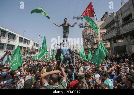 Jabalia, Palästinensische Gebiete. April 2021. Anhänger der islamistischen Bewegung der palästinensischen Hamas schwenken während einer Demonstration gegen die Verschiebung der palästinensischen Wahlen, die am 22. Mai stattfinden sollte, Flaggen. Der palästinensische Präsident Mahmoud Abbas kündigte am Donnerstag an, dass die palästinensischen Wahlen verschoben werden, bis die Teilnahme des Volkes in Ostjerusalem sichergestellt werden kann. Kredit: Mohammed Talatene/dpa/Alamy Live Nachrichten Stockfoto