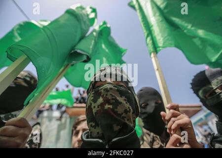 Jabalia, Palästinensische Gebiete. April 2021. Anhänger der islamistischen Bewegung der palästinensischen Hamas schwenken während einer Demonstration gegen die Verschiebung der palästinensischen Wahlen, die am 22. Mai stattfinden sollte, Flaggen. Der palästinensische Präsident Mahmoud Abbas kündigte am Donnerstag an, dass die palästinensischen Wahlen verschoben werden, bis die Teilnahme des Volkes in Ostjerusalem sichergestellt werden kann. Kredit: Mohammed Talatene/dpa/Alamy Live Nachrichten Stockfoto